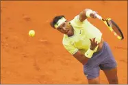  ?? Kenzo Tribouilla­rd / AFP / Getty Images ?? Rafael Nadal serves the ball to Roger Federer during their semifinal Friday at the French Open.