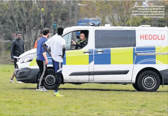  ?? WALES NEWS SERVICE ?? Police break up a football game taking place on Roath Rec in Cardiff, as a group of people ignore the lockdown and social distancing