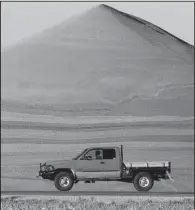  ?? AP/CHARLIE RIEDEL ?? A motorist passes a mountain of milo at a grain storage facility near Canton, Kan., in November.