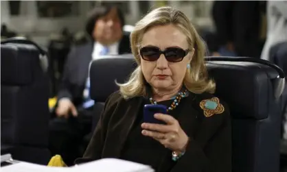  ??  ?? Hillary Clinton checks her phone. Photograph: Kevin Lamarque/AP