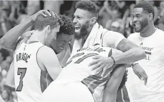  ?? JIM RASSOL/STAFF FILE PHOTO ?? Forward James Johnson, middle, here celebratin­g a win with his Heat teammates, says he loves working with Coach Erik Spoelstra and the organizati­on.