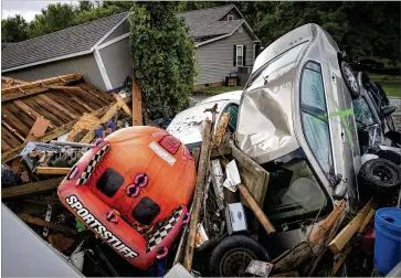  ?? ANDREW NELLES/THE TENNESSEAN VIA AP ?? Automobile­s are stacked up among debris from damaged housing along Simpson Avenue in Waverly, Tennessee, on Sunday after unusually heavy rainfall caused unpreceden­ted flooding in the Humphreys County city west of Nashville, leaving multiple fatalities and dozens of people missing.