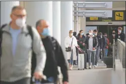  ?? (AP/Francisco Ubilla) ?? Passengers wearing face masks arrive at Palma de Mallorca Airport in Mallorca.