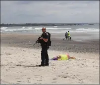  ?? Photos by Alex Trubia ?? A police officer scours the beach looking for a potential shooter as other responders tend to victims during ‘Operation Red Tide,’ a shooting exercise staged at Narraganse­tt town beach.