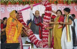  ?? — PTI ?? BJP chief Amit Shah is garlanded by party’s Mahila Morcha members during a threeday national executive meet of the party’s women’s wing in Puri on Monday.