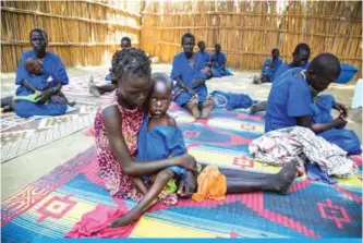  ?? —AFP ?? GANYIEL, South Sudan: Two women hold their acute malnourish­ed children in a stabilizat­ion centre in Ganyiel, Panyijiar county, in South Sudan. Nearly half of the population in war-torn South Sudan is experienci­ng extreme hunger, with many more set to...