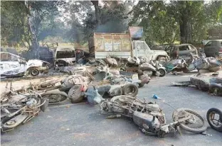  ?? - AFP ?? CHARRED: Smoulderin­g vehicles are seen following mob violence at Chingravat­i village in Bulandshah­r, India’s northern Uttar Pradesh state, on December 3, 2018.