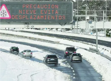  ?? FOTOS: RUBÉN MONDELO ?? Los carteles instaban ayer a no utilizar el coche en una carretera de Madrid con algunos carriles ya despejados de nieve