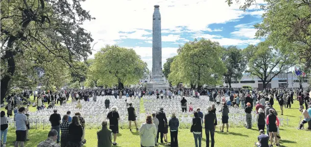  ?? PHOTO: PETER MCINTOSH ?? Rememberin­g . . . Thousands of people took a moment to reflect at the Armistice Day Service at the cenotaph in Queens Gardens in Dunedin yesterday.