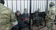  ?? ASSOCIATED PRESS ?? Two British citizens Aiden Aslin, left, and Shaun Pinner, right, and Moroccan Saaudun Brahim, center, sit behind bars in a courtroom in Donetsk, in the territory which is under the Government of the Donetsk People’s Republic control, eastern Ukraine, Thursday.