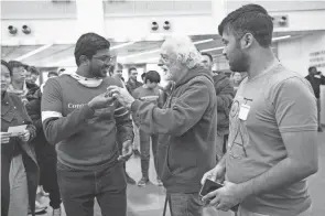  ?? ?? Nobel laureate Pierre Agostini hands back a rupee with his autograph Wednesday to Suriyaa Ramanathan, a graduate student in condensed matter theory, at OSU’S Physics Research Building on the Columbus campus.