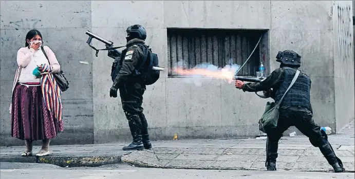  ?? RONALDO SCHEMIDT / AFP ?? Línea de fuego. La policía dispara botes de humo en La Paz contra los partidario­s de Morales, en su mayor parte indígenas, como la señora de la foto