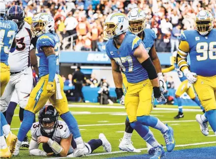  ?? ROBERT GAUTHIER L.A. TIMES ?? Chargers defensive end Joey Bosa (97) celebrates with teammates after stopping Broncos QB Drew Lock at the goal line in the first half.