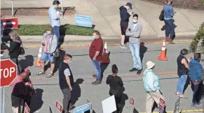  ?? ETHAN HYMAN/THE NEWS & OBSERVER VIA AP ?? Voters wait outside the Herbert C. Young Community Center in Cary, N.C., on Thursday, the first day of early voting.