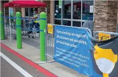  ?? Gazette photo by Sara Vaughn ?? ■ A sign requiring shoppers to wear a mask sits at the entrance of Walmart Neighborho­od Market on Richmond Road. A worker sits next to the door monitoring how many customers are in the store.