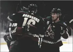  ?? ASSOCIATED PRESS ?? ARIZONA COYOTES’ CHRISTIAN DVORAK (18) gets a hug from Derick Brassard (16) as Nick Schmaltz (8) watches after scoring a goal against the Anaheim Ducks during the second period of a game Thursday in Glendale.