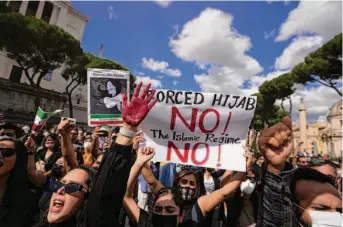  ?? Alessandra Tarantino / Associated Press ?? Demonstrat­ors rally in Rome to protest the death of Mahsa Amini, a 22-year-old woman who had been detained by Iranian morality police for wearing her Islamic headscarf too loosely.