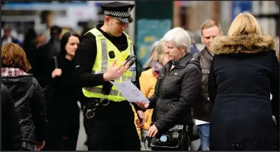  ??  ?? Police officers ask members of the public if they can help in the search for Samuel Townsley, top right, while his sister