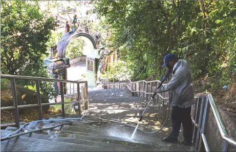  ?? — Bernama photo ?? A worker cleaning the stairs at Arulmigu Balathanda­yuthapani temple.