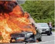  ?? Archivfoto: dpa ?? Ein Auto brennt lichterloh – und ein an derer Fahrer schaut zu.