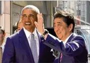  ?? SHIZUO KAMBAYASHI / GETTY IMAGES ?? Former President Barack Obama and Japanese Prime Minister Shinzo Abe pose for photograph­ers in front of a restaurant in Tokyo’s Ginza shopping district on Sunday.
