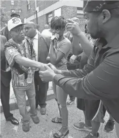  ?? PHOTOS BY STEVE RUARK, AP ?? Elder C. D. Witherspoo­n, right, shakes the hand of Freddie Gray’s father Richard Shipley, as Gray’s twin sister Fredericka Gray, stands nearby after a news conference Wednesday.