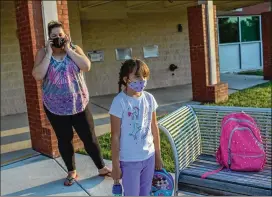  ?? DAYNA SMITH / FOR THE WASHINGTON POST ?? Alexandra Schneider arrived at northern Virginia’s Ashburn Library on Tuesday to drop off her daughter, Elizabeth, 7, for the child care. Many residents went online to express outrage at the decision to use the libraries for child care.