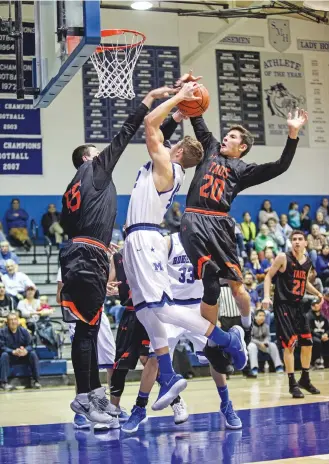  ?? GABRIELA CAMPOS/THE NEW MEXICAN ?? St. Michael’s Lincoln Barker’s shot is blocked by Taos during Friday’s game at St. Michael’s. Taos beat St. Michael’s 71-65 in double overtime.