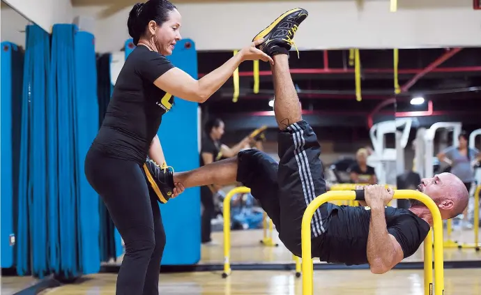  ??  ?? Carlos Castillo y Yivette Carrión, instructor­es “master” de Lebert Training Systems (arriba) demuestran un ejercicio en pareja. A la izquierda, diferentes formas de ejercitart­e utilizando los equipos Lebert Equalizer y Lebert Buddy System.