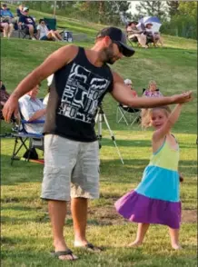  ?? BARB AGUIAR/Westside Weekly ?? Isabelle Helbig, 4, does a spin as she dances to the music of Step’n Stones with Chris Helbig.