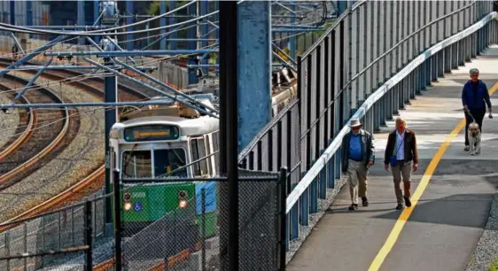  ?? DAVID L. RYAN/GLOBE STAFF ?? With trains on the Green Line extension continuing to crawl Wednesday, walking was a better option for some people.