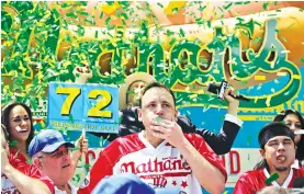  ?? Associated Press ?? Joey Chestnut wins the Nathan’s Famous Hot Dog Eating Contest Tuesday, marking his 10th victory in the event, in the Brooklyn borough of New York. He downed 72 hot dogs and buns in 10 minutes.