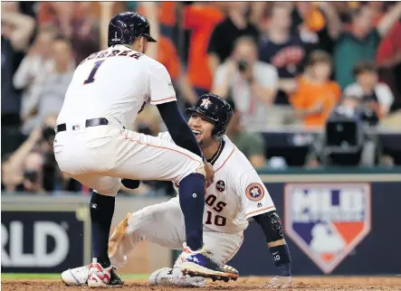  ?? RONALD MARTINEZ/ GETTY IMAGES ?? Houston Astros Carlos Correa and Yuli Gurriel celebrate after they scored on an Alex Bregman double against New York Yankees reliever David Robertson in the eighth inning Friday as the Astros forced Game 7 in the ALCS with a 7-1 win at Minute Maid Park...