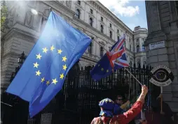  ?? (Toby Melville/Reuters) ?? AN ANTI-BREXIT demonstrat­or holds a flag outside the Prime Minister’s Residence on Downing Street, in London on Monday.