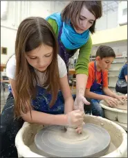  ?? File Photo/ANDY SHUPE ?? Instructor Dani Pugel (top) helps Sadie Skaggs of Bentonvill­e as she creates a clay bowl during the Community Creative Center’s Spring Break Pottery Wheel Camp. The center’s Holiday Gift Market will run through Dec. 16 and features works by local artists.