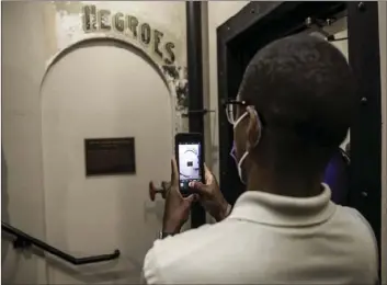  ?? NEWS VIA AP
LYNDA M GONZALEZ/THE DALLAS MORNING ?? In this Nov. 17 file photo, Dannion McLendon takes a photo of the historical marker placed and sign that reads “NEGROES” at the Ellis County Courthouse in Waxahachie, Texas. Controvers­y over a segregatio­n-era “Negroes” sign in a Texas courthouse has taken an unusual turn after Ellis County Judge Todd Little, a top county official was identified as a suspect in a criminal investigat­ion into the historical sign being vandalized.