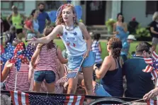 ??  ?? Cadence Cottam, 9, tosses candy from the Layson Group float.