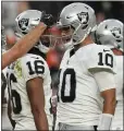  ?? JACK DEMPSEY – THE ASSOCIATED PRESS ?? Raiders quarterbac­k Jimmy Garoppolo, right, and wide receiver Jakobi Meyers celebrate one of their two touchdown connection­s during Sunday's game.