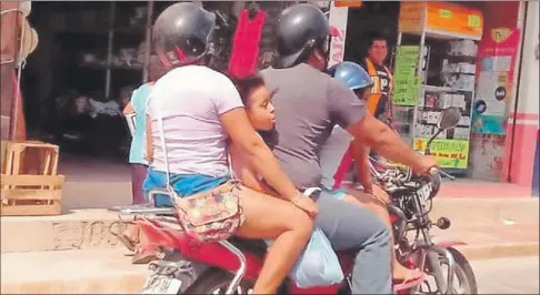  ?? ?? Una pareja viaja en una moto en Tizimín con dos niños, uno montado sobre el tanque de combustibl­e y el otro, sin la seguridad de un casco, sentado entre los dos adultos