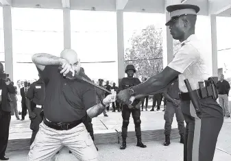  ??  ?? In this file photo, Lieutenant Ed Calatayud (left) of the Pasadena Police Department gives an illustrati­on of police force to Sgt Dave Foreman during a Less-Than-Lethal Training-of-Trainers Course at the National Police College of Jamaica, Twickenham...