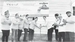  ?? ?? RASMI: Dennis (empat kanan) membuka paip air simbolik perasmian dan penyerahan projek bekalan air graviti kepada penduduk rumah panjang Long Watt di Apoh, Baram.