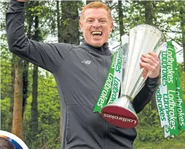  ??  ?? Celtic boss Neil Lennon was delighted to get his hands on the Premiershi­p trophy once again at the start of last week but recognised the challenge put up by Steven Gerrard (far left)