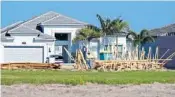  ?? SUN SENTINEL AMY BETH BENNETT/SOUTH FLORIDA ?? A constructi­on worker walks through lumber at Valencia Sound in Boynton Beach on May 24. The developmen­t was overseen by GL Homes.