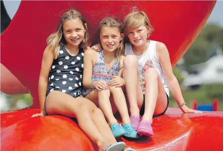  ??  ?? Olivia O'Krancy, 9, left, Fern Lemieux, 9, and Lily Lemieux, 12, take a break on Cadboro-Gyro Park Beach’s popular octopus.