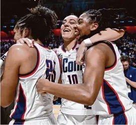  ?? Jessica Hill/Associated Press ?? UConn’s Nika Muhl, center, celebrates with Ice Brady, left, and KK Arnold, right, after beating Georgetown in the Big East Conference tournament final at Mohegan Sun Arena on Monday.