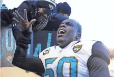  ?? PHILIP G. PAVELY/ USA TODAY SPORTS ?? Outside linebacker Telvin Smith celebrates with Jaguars fans after Jacksonvil­le upset the Steelers 45-42 Sunday in Pittsburgh.