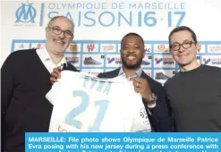  ??  ?? MARSEILLE: File photo shows Olympique de Marseille Patrice Evra posing with his new jersey during a press conference with manager Andoni Zubizarret­a (L) and president Jacques-Henri Eyraud. — AFP