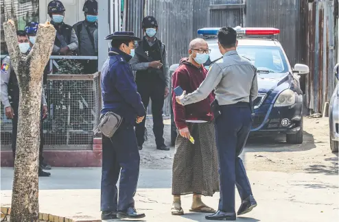  ?? STR / AFP VIA GETTY IMAGES ?? Police escort Buddhist abbot Myawaddy Mingyi Sayadaw at a court compound in Mandalay, Myanmar, on Wednesday following his arrest as a longtime critic of the country’s military.