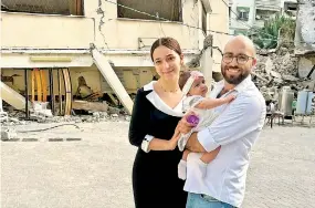  ?? ?? Rami, his wife Maryan, and their daughter Kylie on the day his daughter was baptized, which occurred in late October while they were sheltering in Greek Orthodox Church of St. Porphyrius.