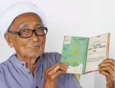  ??  ?? Mokhtar Osman, 92, shows a passport to Mecca that he used to perform the Haj in the 1950s.